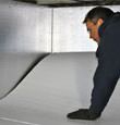 A contractor installing TerraBlock™ floor insulation in a Virginia crawl space