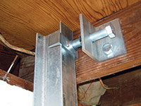 Securing the i-beam system to the top of the floor joist in a foundation wall repair in Virginia.