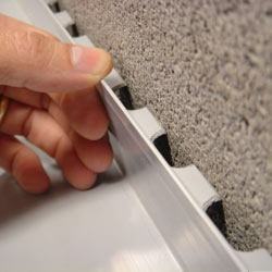A contractor in Crosby installing a perimeter drain tile system during a sump pump installation.