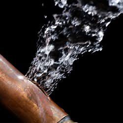 A bursting copper pipe in Brainerd, with water gushing out.