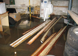A severely flooding basement in Virginia, with lumber and personal items floating in a foot of water