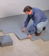 Contractors installing basement subfloor tiles and matting on a concrete basement floor in Hibbing, Minnesota and Wisconsin